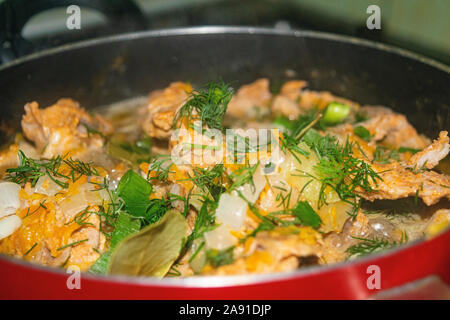 La viande avec les oignons, carottes, aneth et le laurier est mijotée dans une casserole. La cuisine maison Close up. Banque D'Images