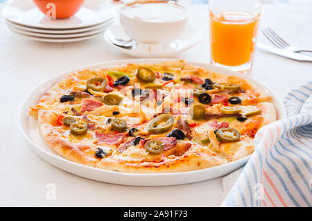 Un mexicain avec Pizza Hot Chili Peppers, jus et café sur une table. Banque D'Images