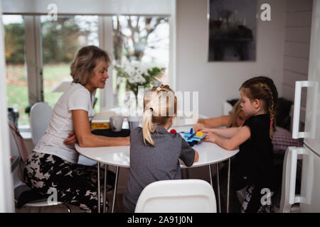 Grand-mère jouer à jeu avec petites-filles Banque D'Images