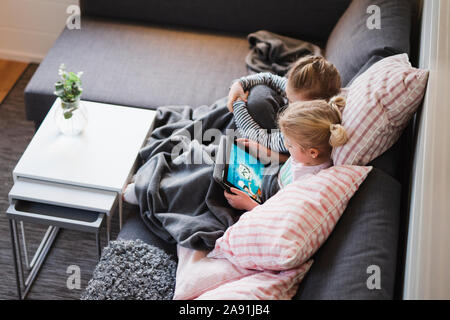 Sisters sitting on sofa Banque D'Images