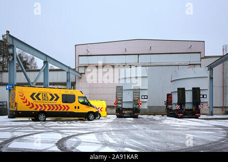 Deux transports de charge surdimensionnée et d'escorte de véhicules sur zone de chargement de l'usine. Le grand navire de composants à partir de la Finlande au Chili. Salo, Finlande. Nov 8, 19 Banque D'Images