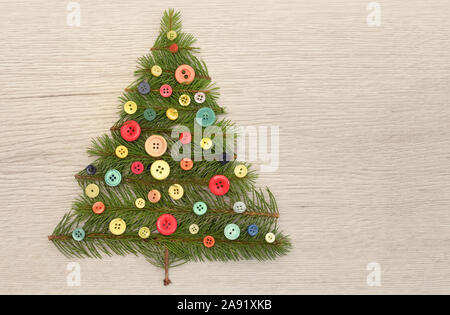 Arbre de Noël avec des branches de pins et boutons sur table en bois Banque D'Images