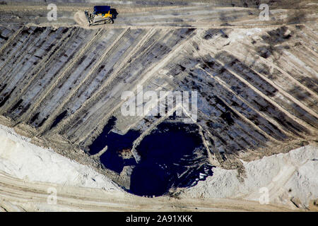 Les bulldozers sont propager le déchets toxiques dans l'un des énormes bassins de résidus à Fort McMurray en Alberta, Canada. Les étangs sont parmi les plus grandes structures de l'homme dans le monde, couvrant plus de 175 kilomètres carrés. Ils représentent un défi supplémentaire pour la production de sables bitumineux : même après avoir terminé la production, il peut prendre jusqu'à 30 ans pour le limon dans les étangs à sécher. L'eau contaminée est toxique pour les êtres vivants. Les sables bitumineux de l'Athabasca-est parmi les plus importantes au monde. Le bitume, aussi communément appelé tar (d'où l'exploitation des sables bitumineux), contient beaucoup d'hydrocarbures, mais est notori Banque D'Images