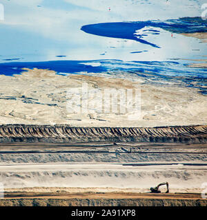 Des bulldozers et de terrassement se répandent les déchets toxiques dans l'un des énormes bassins de résidus à Fort McMurray en Alberta, Canada. Les étangs sont parmi les plus grandes structures de l'homme dans le monde, couvrant plus de 175 kilomètres carrés. Ils représentent un défi supplémentaire pour la production de sables bitumineux : même après avoir terminé la production, il peut prendre jusqu'à 30 ans pour le limon dans les étangs à sécher. L'eau contaminée est toxique pour les êtres vivants. Les sables bitumineux de l'Athabasca-est parmi les plus importantes au monde. Le bitume, aussi communément appelé tar (d'où l'exploitation des sables bitumineux), contient beaucoup de hydrocarbo Banque D'Images