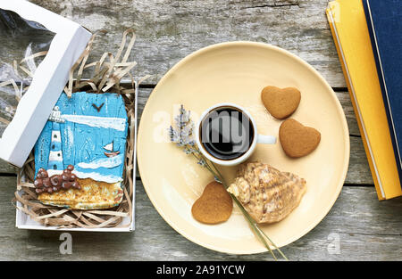 Petit-déjeuner scandinave à la mer : café, biscuits en forme de coeur, lavande, Shell et des livres sur la vieille table en bois patiné, profiter de moments simples de votre Banque D'Images