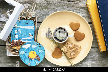 Petit-déjeuner scandinave à la mer : café, biscuits en forme de coeur, lavande, Shell et des livres sur la vieille table en bois patiné, profiter de moments simples de votre Banque D'Images