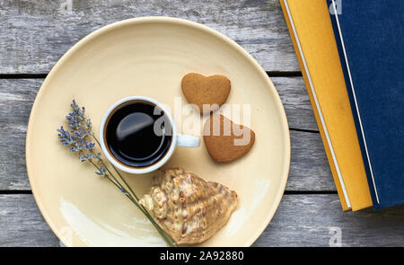 Petit-déjeuner scandinave à la mer : café, biscuits en forme de coeur, lavande, Shell et des livres sur la vieille table en bois patiné, profiter de moments simples de votre Banque D'Images