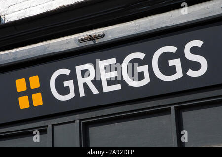 Essex, UK - 27 août 2019 : Les Greggs bakery logo ci-dessus l'entrée de leur boutique dans l'abbaye de Waltham, Essex, Royaume-Uni. Banque D'Images