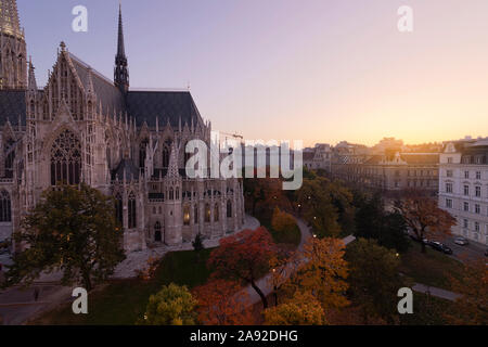 Panorama de Vienne au coucher du soleil. Couleurs d'automne, l'église néogothique Votivkirche au premier plan. Banque D'Images