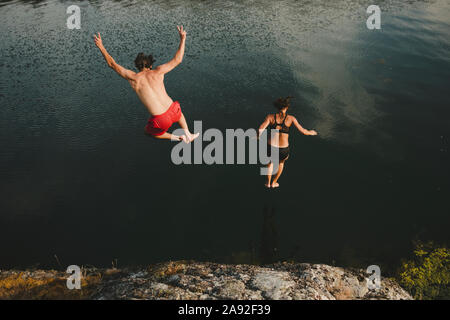 Homme et femme sautant dans la mer Banque D'Images