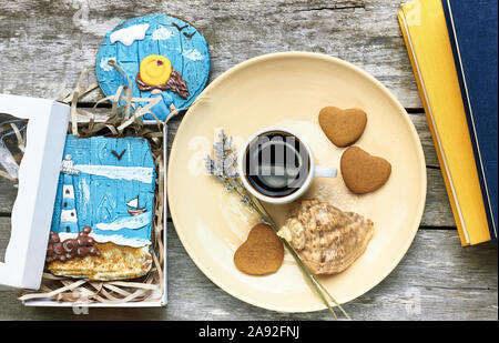 Petit-déjeuner scandinave à la mer : café, biscuits en forme de coeur, lavande, Shell et des livres sur la vieille table en bois patiné, profiter de moments simples de votre Banque D'Images