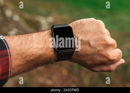 Smartwatch sur male hiker part, maquette vierge écran close up avec selective focus Banque D'Images