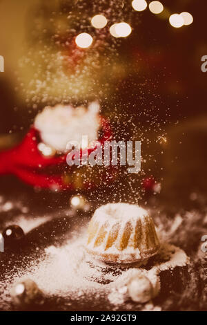 Noël au chaud à la maison avec un sweet mini gâteau bundt, le sucre en poudre sur une mini hot chaud Gâteau bundt avec ornement de Noël et une tasse de flou artistique Banque D'Images