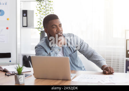 African American pensif assis à l'employé de bureau moderne en milieu de travail Banque D'Images