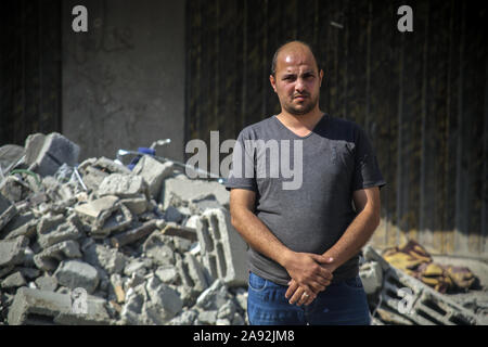 Gaza, Territoires palestiniens. 12 Nov, 2019. Le voisin Ahmad Helles se trouve en face de la maison de l'du Jihad islamique Baha Abu Al Ata, qui a été endommagée à la suite d'un raid aérien israélien. Les forces de sécurité d'Israël ont pris des mesures ciblées afin de tuer le chef militaire du Jihad islamique dans la bande de Gaza. Israël a déclaré qu'il ne serait pas revenir à une politique d'assassinat ciblé. Selon l'armée, il s'agissait d'une action unique pour éviter "une menace directe'. Credit : Saud Abu Ramadan/dpa/Alamy Live News Banque D'Images