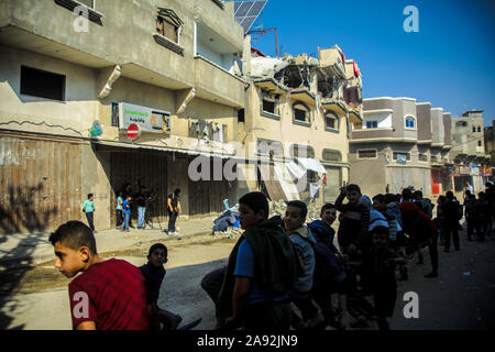 Gaza, Territoires palestiniens. 12 Nov, 2019. Après un raid aérien israélien, les passants se tenir en face de la maison endommagée du dirigeant du Jihad islamique Baha Abu Al Ata. Les forces de sécurité d'Israël ont pris des mesures ciblées afin de tuer le chef militaire du Jihad islamique dans la bande de Gaza. Israël a déclaré qu'il ne serait pas revenir à une politique d'assassinat ciblé. Selon l'armée, il s'agissait d'une action unique pour éviter "une menace directe'. Credit : Saud Abu Ramadan/dpa/Alamy Live News Banque D'Images