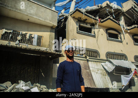 Tel Aviv, Territoires palestiniens. 12 Nov, 2019. Le voisin Ali Saad se trouve en face de la maison de l'du Jihad islamique Baha Abu Al Ata, qui a été endommagée à la suite d'un raid aérien israélien. Les forces de sécurité d'Israël ont pris des mesures ciblées afin de tuer le chef militaire du Jihad islamique dans la bande de Gaza. Israël a déclaré qu'il ne serait pas revenir à une politique d'assassinat ciblé. Selon l'armée, il s'agissait d'une action unique pour éviter "une menace directe'. Credit : Saud Abu Ramadan/dpa/Alamy Live News Banque D'Images