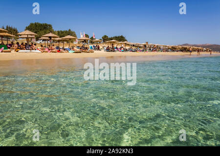 Complexe avec chaises et abri le long de la plage de Plaka sur la mer Méditerranée ; île de Naxos, Cyclades, Grèce Banque D'Images