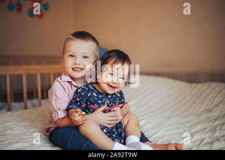Petit frère de 3 ans et sa soeur 1 ans hugging on bed Banque D'Images