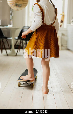 Planche à roulettes fille à la maison Banque D'Images