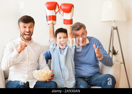 Garçon, père et grand-père à regarder le match de boxe à la télévision Piscine Banque D'Images