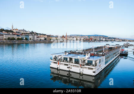 Danube à Budapest, Hongrie avec de grands bateaux de croisière sur une froide journée d'hiver. Centre historique de la capitale hongroise dans l'arrière-plan. La pollution de l'environnement croisieres est problème. Banque D'Images