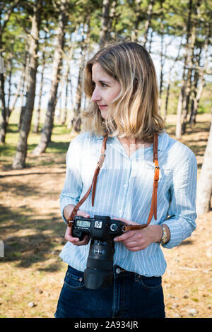 Young woman holding camera Banque D'Images