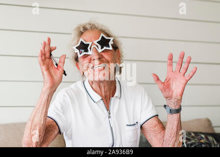 Heureux femme portant des lunettes de soleil en forme d'étoile Banque D'Images