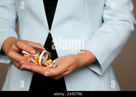 Comprimés de femmes, la femme en bleu office suit holding bouteille avec des capsules, selective focus. Concept de vitamines pour la beauté, soins de la peau Banque D'Images