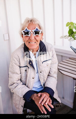 Femme portant des lunettes de soleil en forme d'étoile Banque D'Images