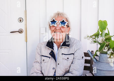 Femme portant des lunettes de soleil en forme d'étoile Banque D'Images