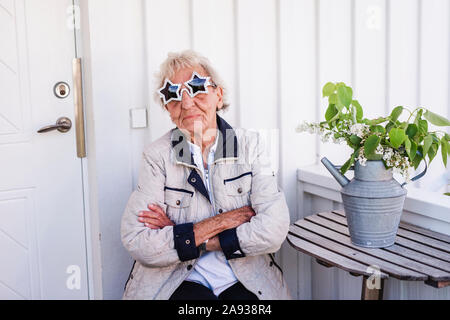 Femme portant des lunettes de soleil en forme d'étoile Banque D'Images
