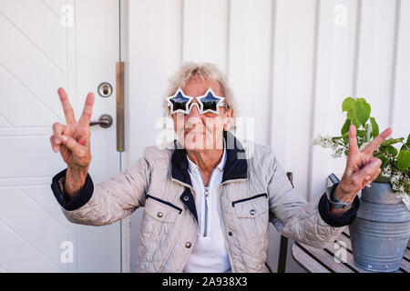 Femme portant des lunettes de soleil en forme d'étoile Banque D'Images