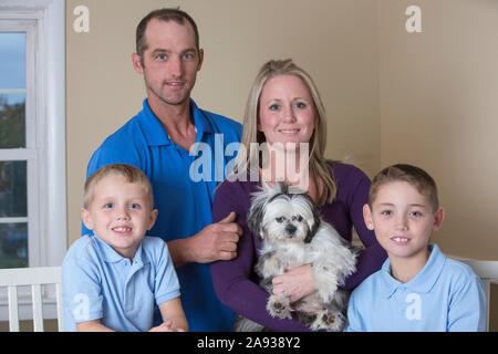 Portrait d'une famille heureuse avec des troubles de l'audition avec un chiot Banque D'Images