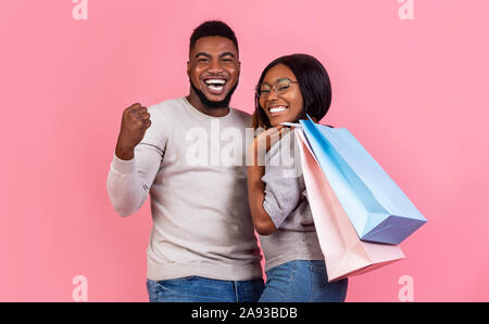 Happy black woman holding shopping bags and smiling Banque D'Images