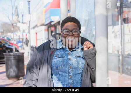 Portrait d'une femme heureuse avec le trouble bipolaire shopping dans elle quartier Banque D'Images