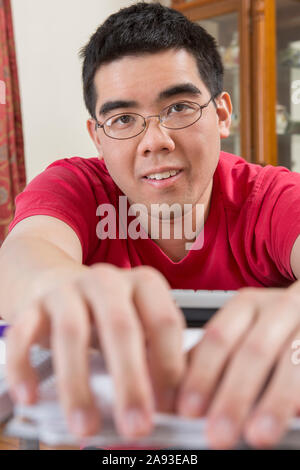 Portrait de l'homme asiatique avec l'autisme travaillant dans sa maison Banque D'Images