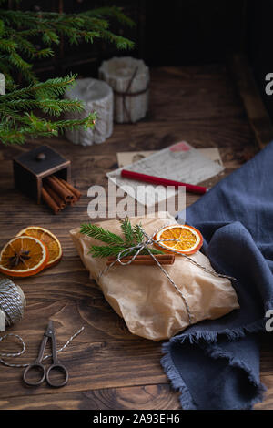 Gâteau Stollen traditionnel européen avec les noix et fruits confits enveloppée dans un morceau de papier brun sur le fond en bois Banque D'Images