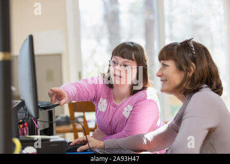 Fille avec le syndrome de Down et sa mère utilisant l'ordinateur Banque D'Images