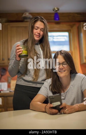 Femme atteinte de sclérose en plaques discutant avec sa fille d'un message texte sur le téléphone Banque D'Images