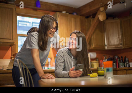 Femme atteinte de sclérose en plaques discutant avec sa fille d'un message texte sur le téléphone Banque D'Images