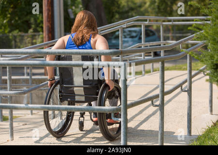 Femme atteinte de la moelle épinière en utilisant une rampe pour fauteuil roulant Banque D'Images