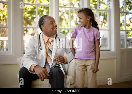 Friendly senior doctor smiling à un jeune patient. Banque D'Images