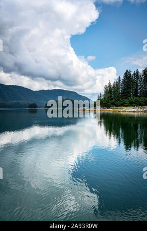 Nuage spectaculaire et son reflet dans l'eau calme dans le sud-est de l'Alaska en été. Banque D'Images