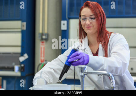 Chimiste de laboratoire à la pipette pour recueillir quantité mesurée de solution standard Banque D'Images