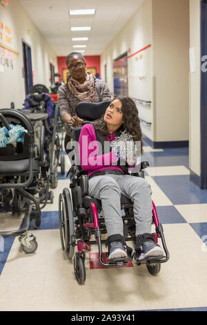 Fille atteinte de sclérose tubéreuse apprenant à l'école avec gardien Banque D'Images