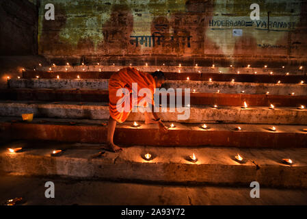 Varanasi, Inde. 12 Nov, 2019. Un moine indien allume les lampes sur la veille de Dev Deepavali à Varanasi.Dev Deepavali est le plus grand festival de la lumière de l'Inde où les dévots décorer la rivière du Gange avec des millions de lampes dans le cadre du festival. Credit : Avishek Das/SOPA Images/ZUMA/Alamy Fil Live News Banque D'Images