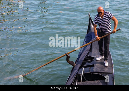 Venise, Italie - 20 juillet 2019 : un gondolier propulsion d'une cabine dans la ville de Venise, Italie. Banque D'Images