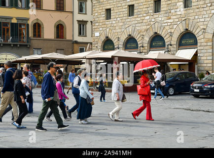 Un groupe de touristes asiatiques à la suite d'un guide touristique vêtu de rouge sur la Piazza della Signoria, UNESCO World Heritage Site, Florence, Toscane, Italie Banque D'Images