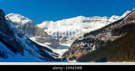 Vue panoramique sur la montagne enneigée d'un glacier, lac enneigé avec ciel bleu profond; Lake Louise, Alberta, Canada Banque D'Images